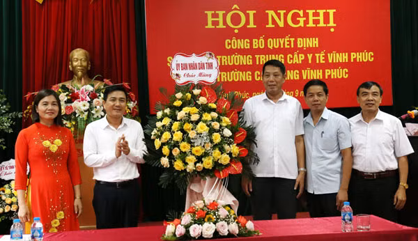 Ông Vũ Việt Văn, Phó Chủ tịch UBND tỉnh Vĩnh Phúc (thứ 2 từ trái qua) tặng hoa chúc mừng BGH Trường Cao đẳng Vĩnh Phúc