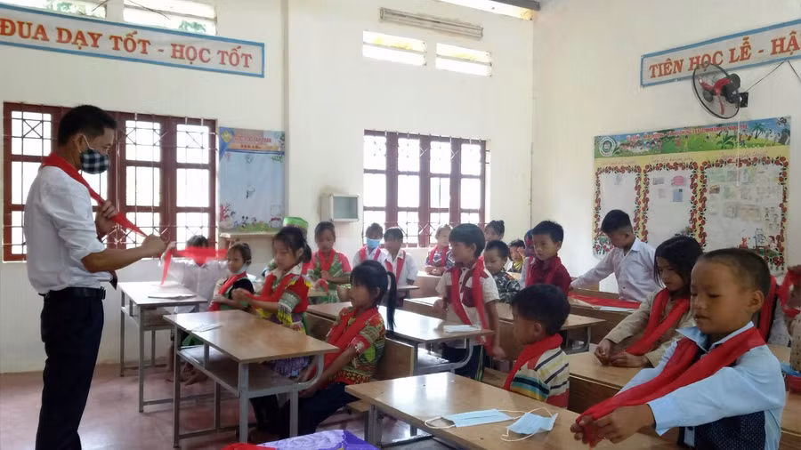 Thầy giáo Trường Tiểu học Tây Tiến hướng dẫn học sinh thắt khăn quàng đỏ.