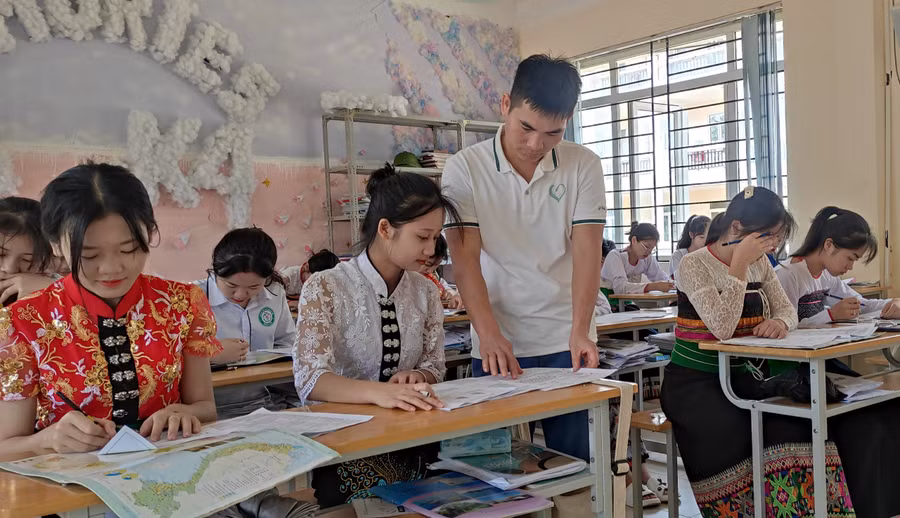 Em Phạm Thị Lan Anh (lớp 12A4 - áo đỏ) cùng các bạn đang được thầy giáo tập trung truyền đạt kiến thức để chuẩn bị cho kỳ thi tốt nghiệp sắp tới. Ảnh: Thế Lượng.