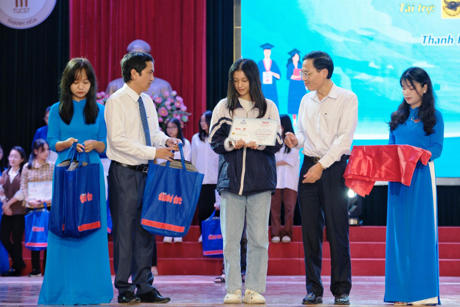 Ông Đầu Thanh Tùng - Phó Chủ tịch UBND tỉnh Thanh Hóa (ảnh phải) và nhà báo Nguyễn Phan - Tổng thư ký tòa soạn Báo Tuổi trẻ trao học bổng cho tân sinh viên.