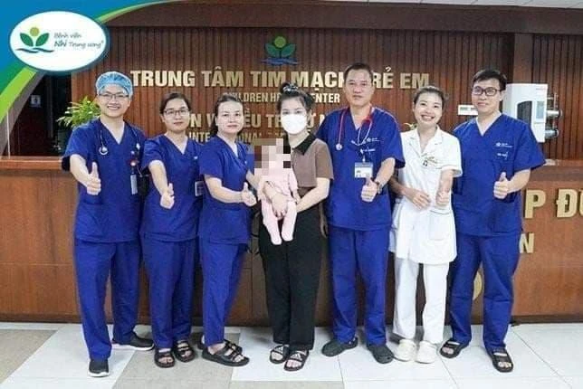 Hai mẹ con bé P.S chụp ảnh lưu niệm cùng các y bác sĩ Trung tâm Tim mạch, Bệnh viện Nhi Trung ương. Ảnh: BV.