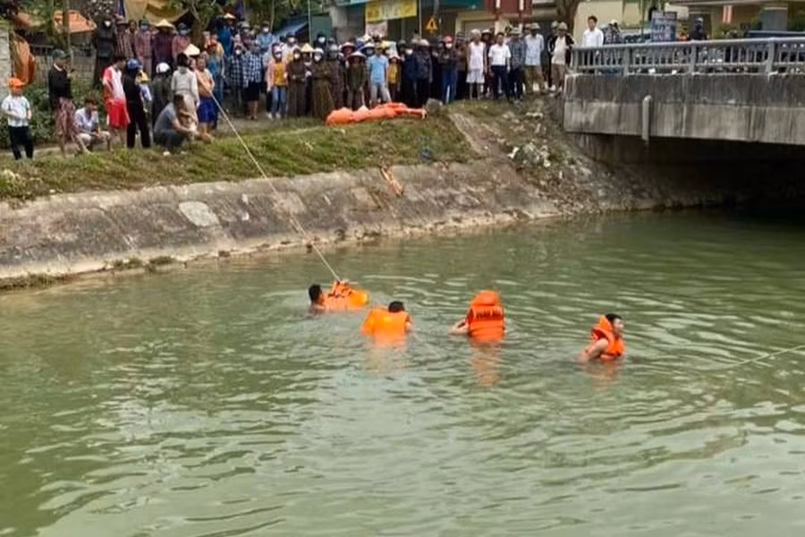 Chính quyền địa phương huy động lực lượng lặn mò, tìm kiếm dưới sông nghi có người nhảy cầu. Ảnh: NDCC
