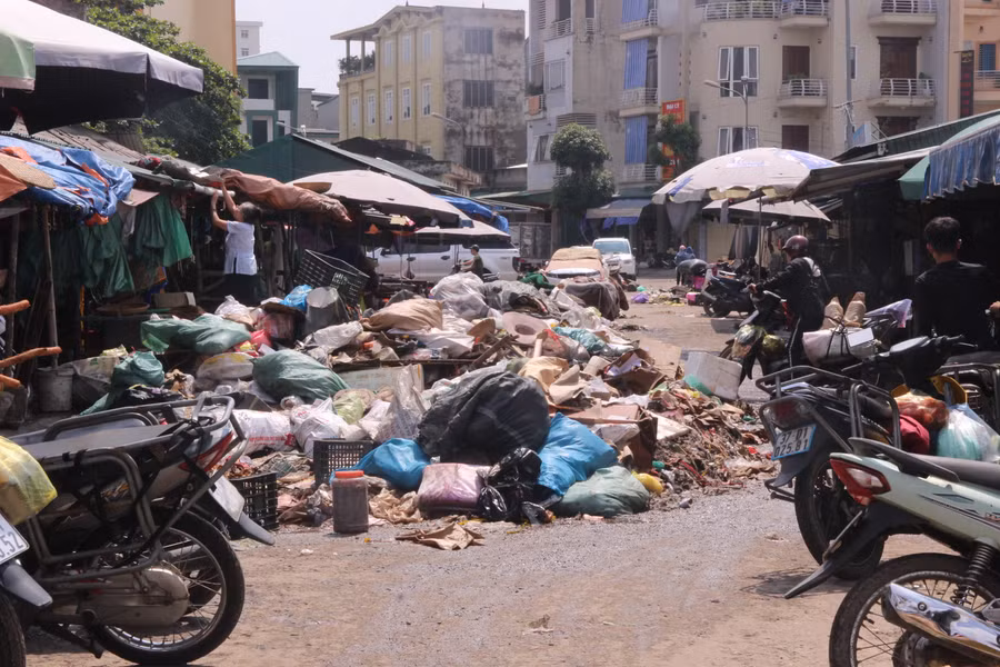 Từng đống rác chất cao là hàng hóa bị hư hỏng sau lụt phải bỏ đi