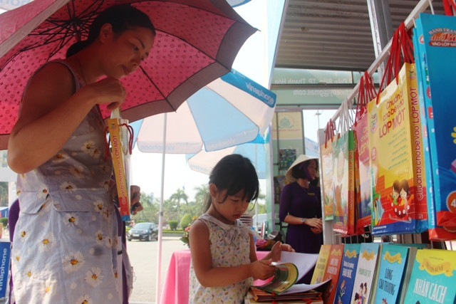 Hai mẹ con cùng nhau đến chọn mua sách tại cuộc triển lãm