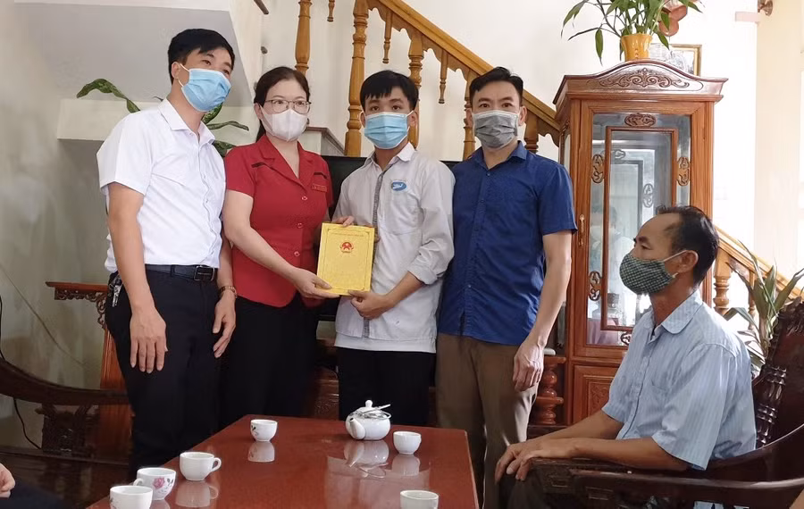 Bà Lương Thị Hoa - Phó Bí thư Thường trực Huyện ủy và lãnh đạo UBND huyện Thiệu Hóa tặng quà cho em Dương Văn Giới.