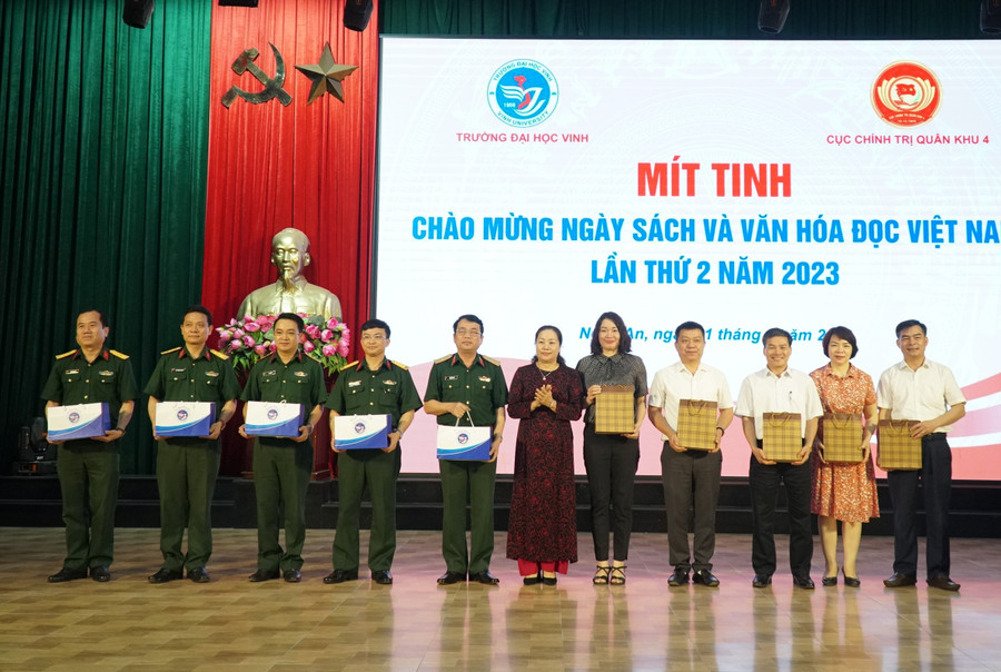 Bà Nguyễn Thu Hường - Trưởng ban Tuyên giáo tỉnh ủy Nghệ An trao quà lưu niệm cho Cục Chính trị Quân khu IV và Trường ĐH Vinh nhân dịp mít tinh chào mừng Ngày Sách và Văn hóa đọc Việt Nam năm 2023. Ảnh: Hồ Lài.