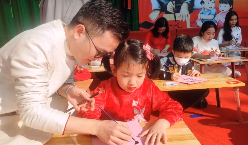 Thành viên Câu lạc bộ Thư pháp TP Thanh Hóa hướng dẫn học sinh viết chữ thư pháp.