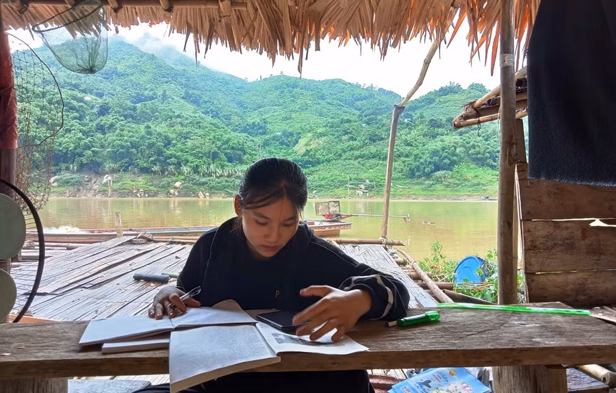 Em Ngân Thị Khanh, học sinh Trường THPT Mường Lát phải xuống bè cá của gia đình ở sông Mã (xã Trung Lý, Mường Lát) để hứng sóng điện thoại, học trực tuyến.