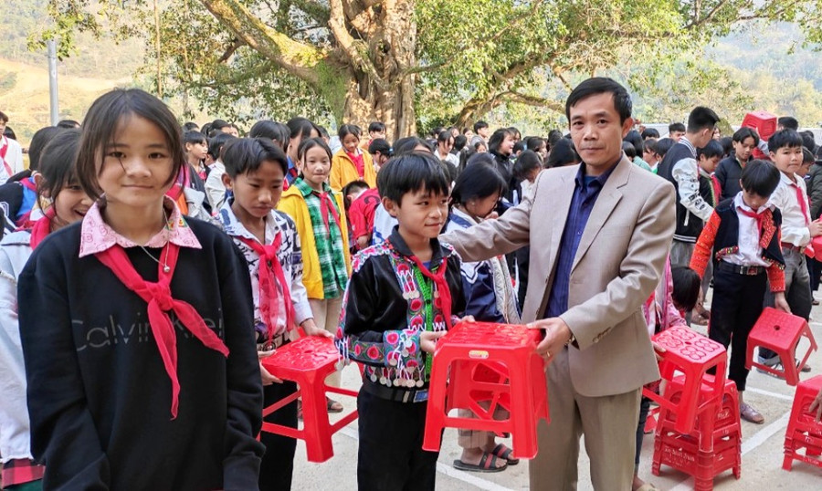 Thầy Nguyễn Thế Lập - Phó Hiệu trưởng nhà trường trao ghế cho học sinh. Ảnh: Thế Lượng.