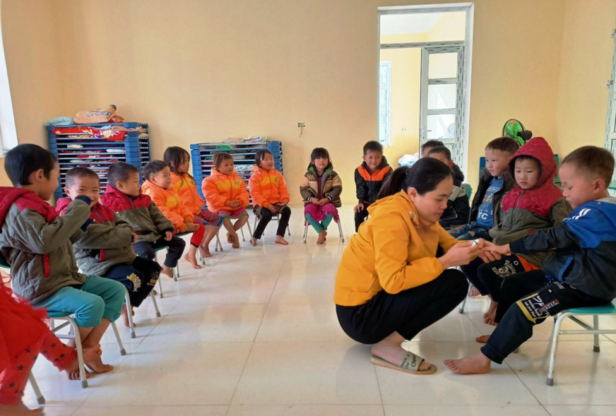 Giáo viên Trường mầm non Tam Chung (Mường Lát) chăm sóc cho trẻ. Ảnh: Thế Lượng.