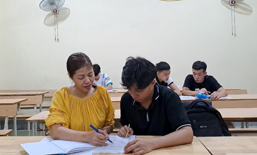 Cô Hồ Thị Thúy, giáo viên tiếng Anh - Trường THPT Quế Phong phụ đạo cho những em còn yếu môn tiếng Anh. Ảnh: NTCC.