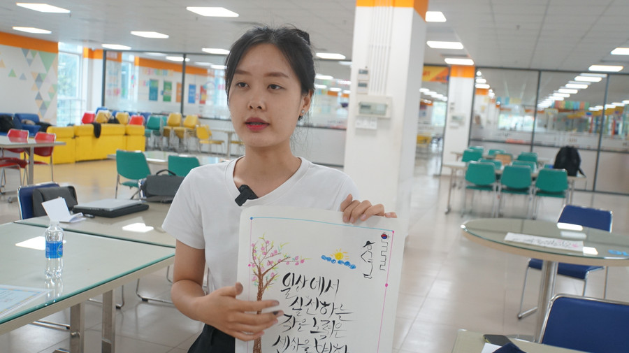 Sinh viên giới thiệu sản phẩm trong cuộc thi viết thư pháp chữ Hàn. Ảnh: Mạnh Tùng