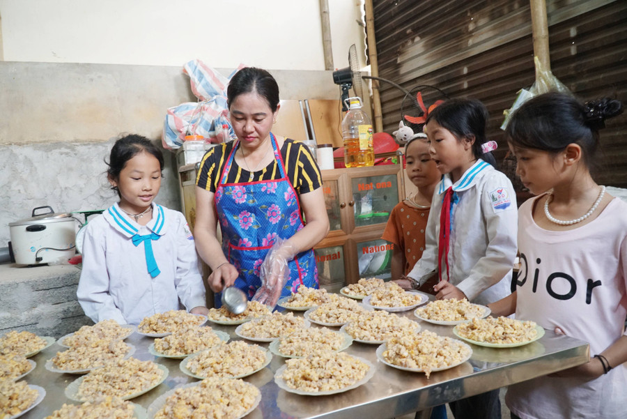 Mỗi bữa ăn, học sinh sẽ xuống bếp phụ giúp cô nuôi chia thức ăn ra từng đĩa và mang ra bàn ăn được quy định. Ảnh: Hồ Lài.