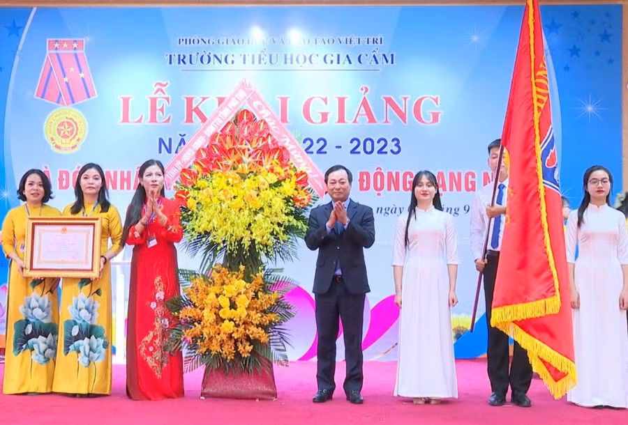 Thừa ủy quyền của Chủ tịch nước, ông Bùi Văn Quang - Chủ tịch UBND tỉnh Phú Thọ (bên phải) trao Huân chương Lao động hạng Nhất và tặng lẵng hoa tươi thắm cho Trường Tiểu học Gia Cẩm, thành phố Việt Trì.