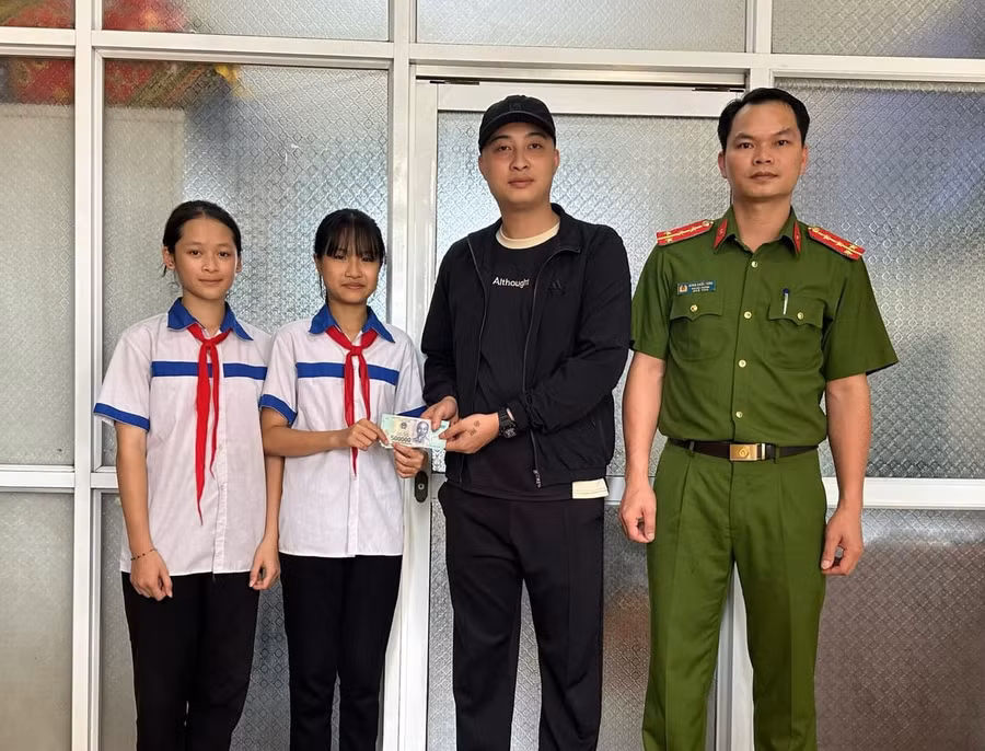 Hai em Như và Nhung trả lại tiền cho người đánh rơi. Ảnh: Công an huyện Hàm Yên