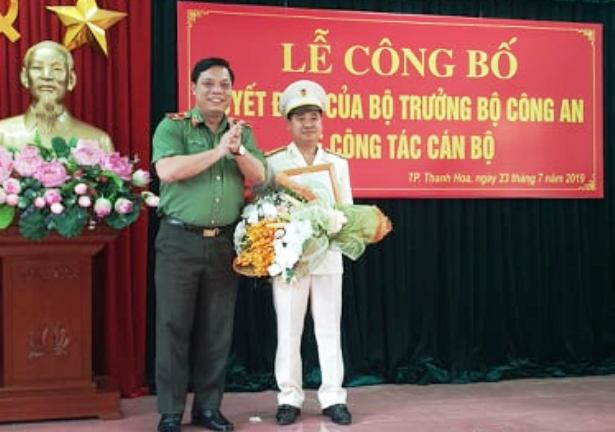 Thừa ủy quyền của Bộ trưởng Bộ Công an, Thiếu tướng Nguyễn Hải Trung trao quyết định, tặng hoa cho thượng tá Lê Ngọc Anh.