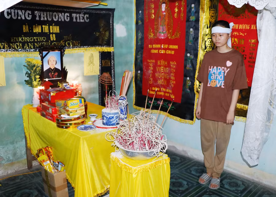 Đầu đội khăn tang, Hoàng Thị Hải Yến lặng lẽ đứng bên bàn thờ bố đáp những người thân quen đến thăm viếng.