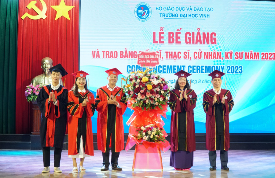 Đại diện tân tiến sĩ, thạc sỹ, cử nhân và kỹ sư năm 2023 gửi lẵng hoa cảm ơn lãnh đạo Trường ĐH Vinh tại lễ bế giảng. Ảnh: Hồ Lài.