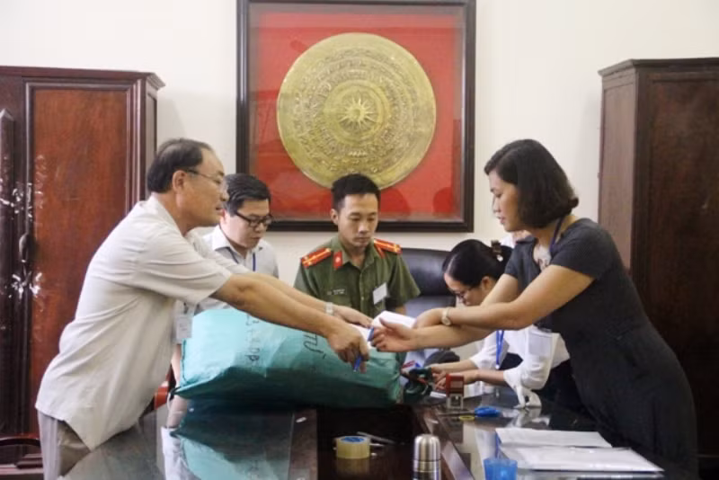 Bàn giao đề thi TN THPT cho giám thi coi thi có cả lực lượng công an giám sát. Ảnh tư liệu.