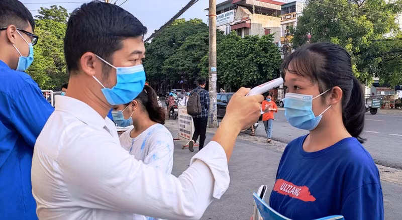 Thí sinh đến dự thi được kiểm tra thân nhiệt để phòng tránh dịch bệnh Covid-19. Ảnh tư liệu.