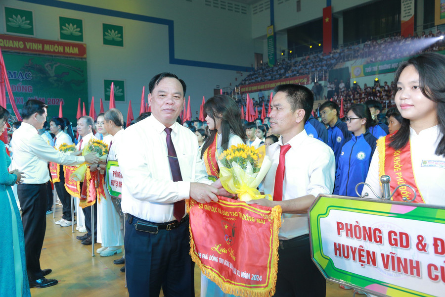 Quyền Chủ tịch UBND tỉnh Võ Tấn Đức trao cờ lưu niệm cho các đơn vị tham dự Hội khỏe Phù Đổng tỉnh Đồng Nai lần thứ 11. Ảnh: Phúc Minh. hi