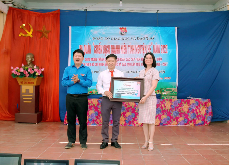 Đ/c Trần Đình Hà, Hiệu trưởng trường THCS Minh Thuận, đại diện nhà trường nhận biển 30 chiếc laptop từ Đ/c Vũ Thị Hạnh - Phó bí thư thường trực Đảng ủy Bộ Giáo dục &amp; Đào tạo và Đ/c Phó bí thư Đoàn Bộ GD&amp;ĐT