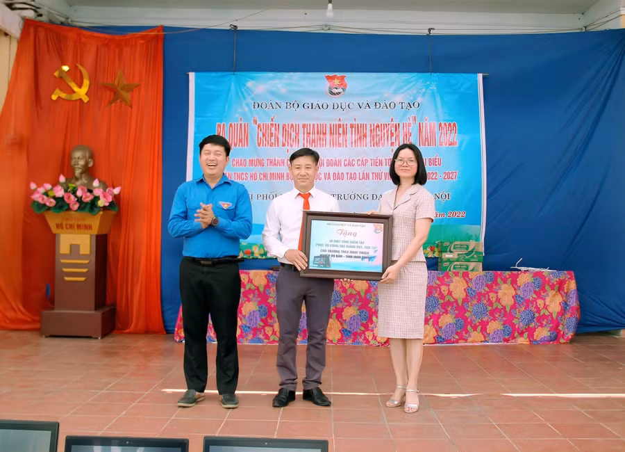Đ/c Trần Đình Hà, Hiệu trưởng trường THCS Minh Thuận, đại diện nhà trường nhận biển 30 chiếc laptop từ Đ/c Vũ Thị Hạnh - Phó bí thư thường trực Đảng ủy Bộ Giáo dục &amp; Đào tạo và Đ/c Phó bí thư Đoàn Bộ GD&amp;ĐT