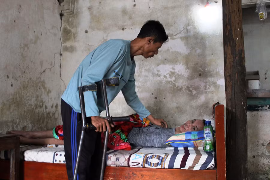 Hàng ngày, anh Bình và vợ phải thay phiên nhau nhau chăm sóc, cho em ăn uống và tắm rửa.