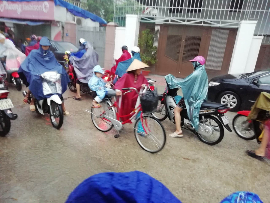 Bà đội áo mưa chở cháu bằng xe đạp đến trường vào sáng ngày 16/10 Bà đội áo mưa chở cháu bằng xe đạp đến trường vào sáng ngày 16/10