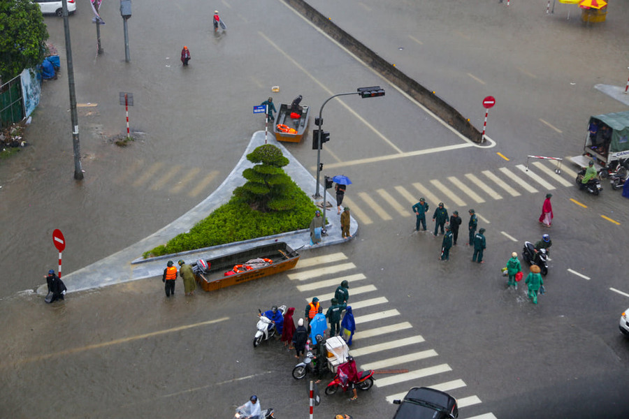 Cơ quan chức năng đưa xuồng ra trực ngã tư chợ Vinh để hỗ trợ đưa người dân qua đoạn nước ngập sâu