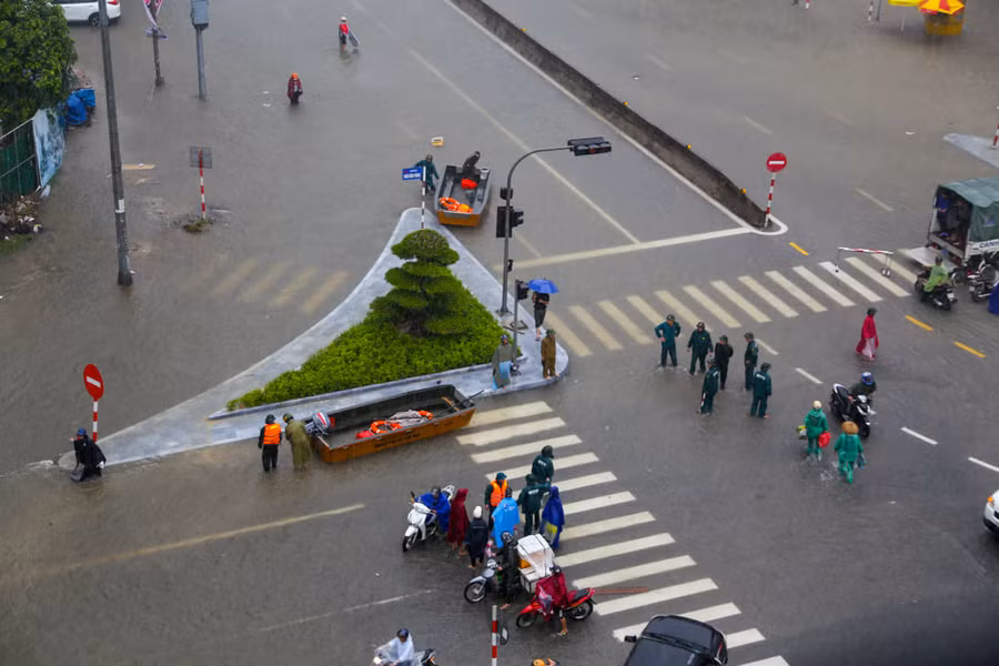Cơ quan chức năng đưa xuồng ra trực ngã tư chợ Vinh để hỗ trợ đưa người dân qua đoạn nước ngập sâu