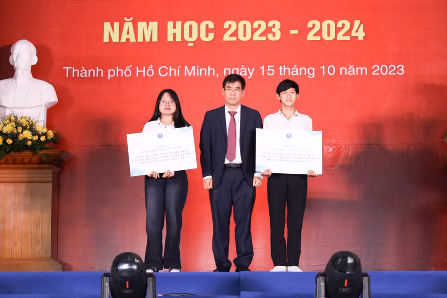 TS. Lê Trường Sơn, Hiệu trưởng Trường Đại học Luật TPHCM trao 2 suất học bổng toàn phần cho sinh viên. Ảnh: HCMULAW