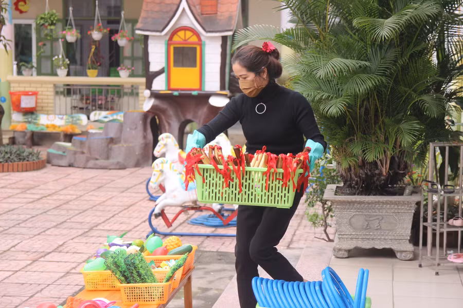 Cô giáo trường Mầm non Hoa Sen (TP Vinh) đưa đồ chơi của trẻ ra vệ sinh, phơi khô