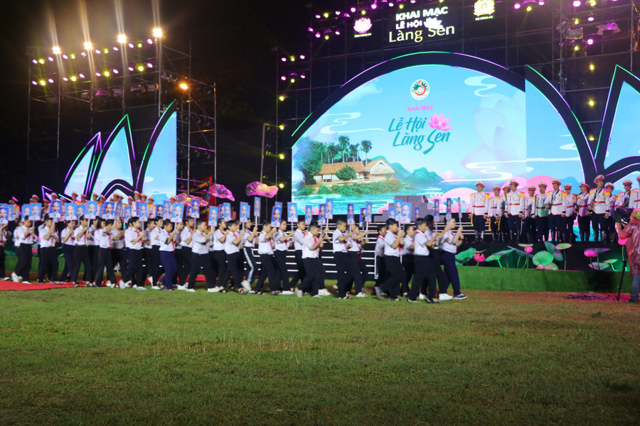 Lễ rước ảnh Bác từ Nhà tưởng niệm ra sân vận động Làng Sen với 134 bức ảnh tương ứng kỷ niệm 134 năm ngày sinh của Người cùng với đội kèn của Bộ Công an. (Ảnh: Hồ Lài)