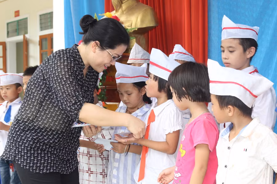 Bà Nguyễn Thị Kim Chi - GĐ Sở GD&ĐT Nghệ An tặng quà cho học sinh có gia đình chịu thiệt hại do bão tại xã Mỹ Lý (huyện Kỳ Sơn)