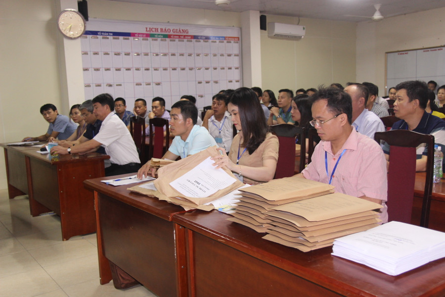 Các giám thị chuẩn bị giấy nháp, phiếu trả lời trắc nghiệm cho buổi thi Tổ hợp kHTN