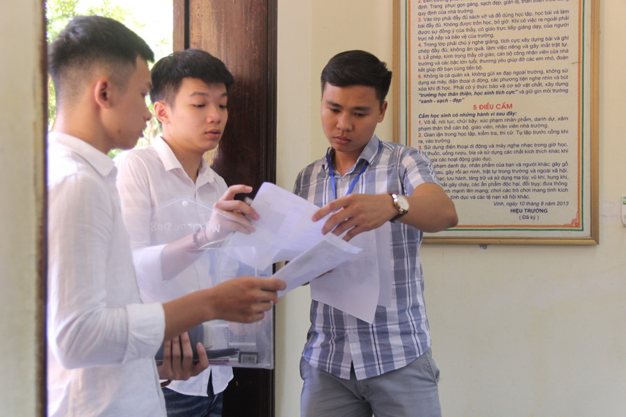 Giám thị kiểm tra thẻ dự thi của thí sinh.