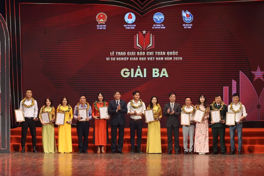 Ông Vũ Minh Đức (thứ 6 từ trái sang) - Chủ tịch Công đoàn GD Việt Nam và ông Nguyễn Văn Hiếu - Phó Cục trưởng Cục Báo chí Bộ Thông tin Truyền thông (thứ 5 từ phải sang) trao giải Ba cho các tác giả đoạt giải