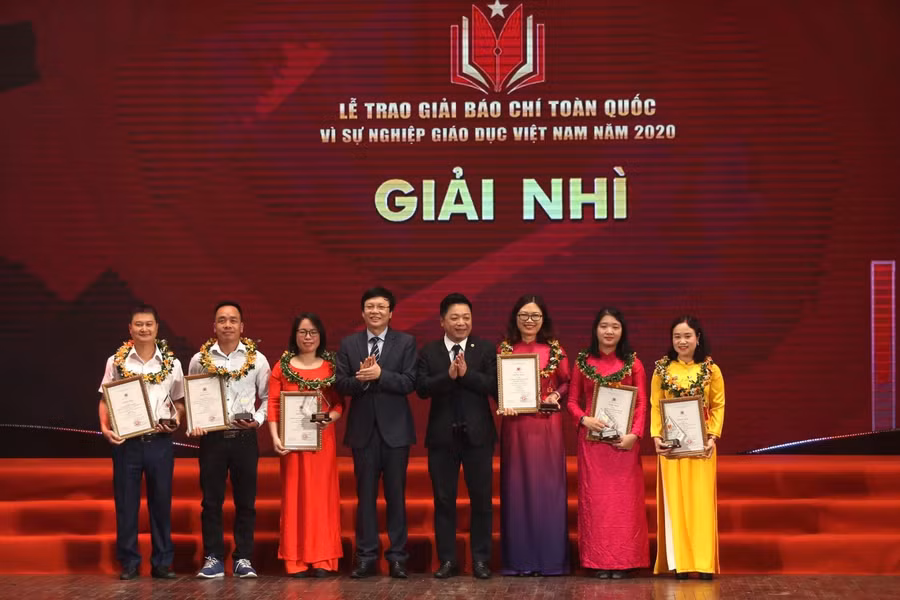 Ông Hồ Quang Lợi - Phó Chủ tịch thường trực Hội Nhà báo Việt Nam (thứ tư từ trái sang), ông Quế Đình Nguyên, Phó Tổng biên tập Báo Nhân dân (thứ tư từ phải sang) trao giải cho các tác giả đoạt giải Nhì