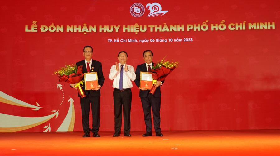 PGS.TS Bùi Anh Tuấn (bìa phải) và PGS.TS Nguyễn Xuân Minh nhận Huy hiệu Thành phố Hồ Chí Minh. Ảnh: Mạnh Tùng