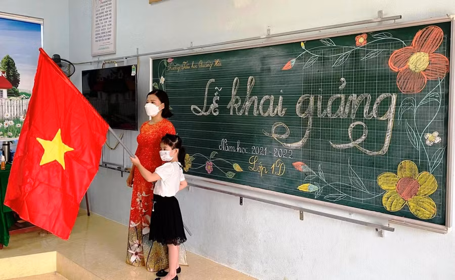 Cô và trò Trường Tiểu học Quảng Hải (Quảng Xương, Thanh Hóa) chào cờ trong buổi khai giảng.