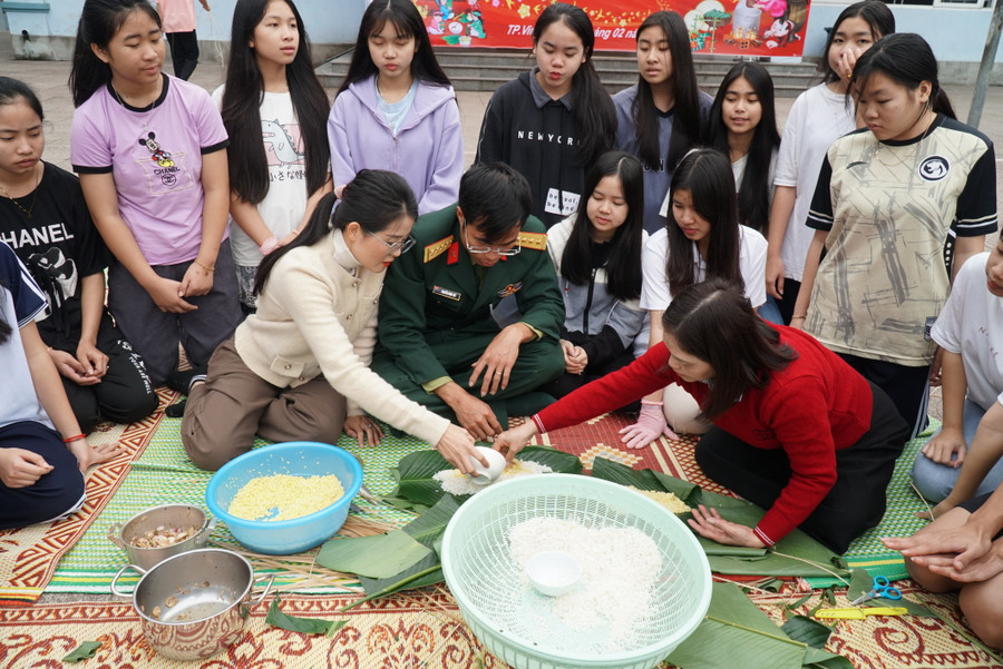 Đại úy Nguyễn Đình Thế - Chính trị viên phó Tiểu đoàn 2, Lữ đoàn 654 hướng dẫn các bạn lưu học sinh Lào gói bánh chưng, bánh tét truyền thống của Việt Nam. Ảnh: Hồ Lài Đại úy Nguyễn Đình Thế - Chính trị viên phó Tiểu đoàn 2, Lữ đoàn 654 hướng dẫn các bạn lưu học sinh Lào gói bánh chưng, bánh tét truyền thống của Việt Nam. Ảnh: Hồ Lài