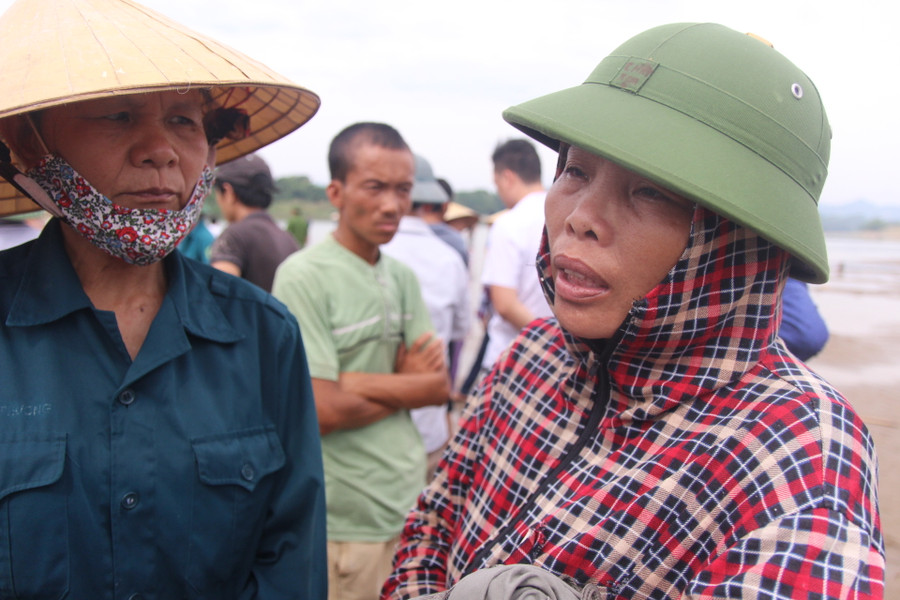 Những người dân đau lòng đứng ngóng trên bờ sông