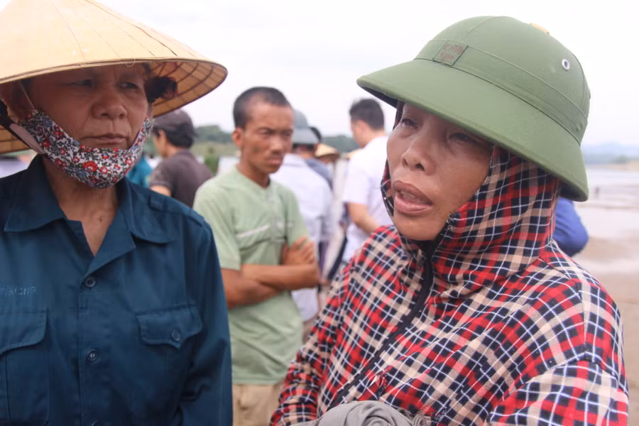 Những người dân đau lòng đứng ngóng trên bờ sông