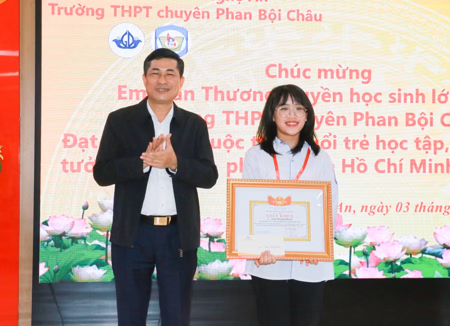 Ông Thái Văn Thành - Giám đốc Sở GD&ĐT Nghệ An chúc mừng em Trần Thương Huyền - học sinh lớp 12C7 Trường THPT chuyên Phan Bội Châu.