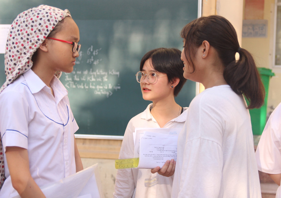 Thí sinh nán lại trường thi trao đổi về bài làm với bạn bè Thí sinh nán lại trường thi trao đổi về bài làm với bạn bè