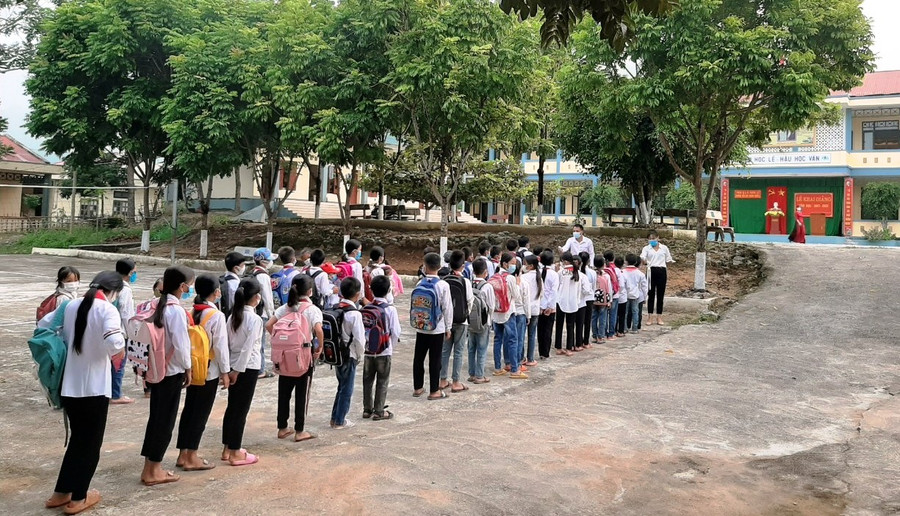 Học sinh Trường Tiểu học Quang Chiểu I xếp hàng chờ kiểm tra thân nhiệt trước khi vào lớp.