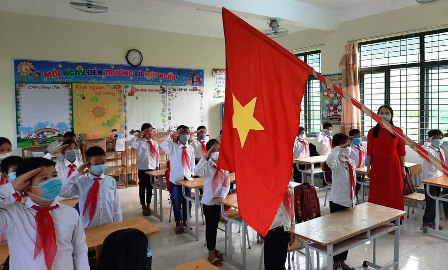 Cô và trò Trường Tiểu học Quang Chiểu I (Mường Lát) chào cờ trong lớp học.