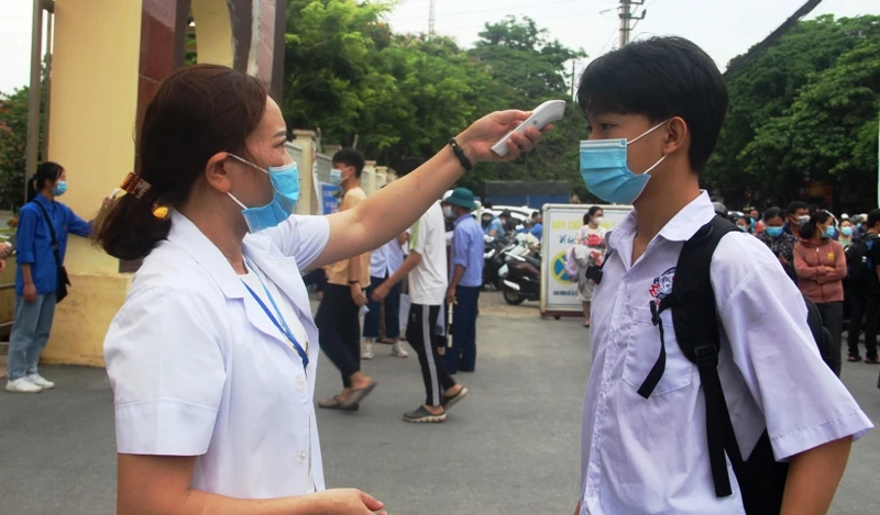 Kiểm tra thân nhiệt cho học sinh để phòng, chống dịch bệnh Covid-19.