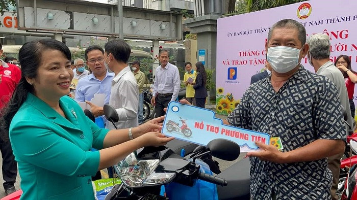 Chủ tịch Ủy ban Mặt trận Tổ quốc Việt Nam TPHCM Trần Kim Yến trao tặng phương tiện cho người dân trong một chương trình hỗ trợ người nghèo. Ảnh: HCM CityWeb